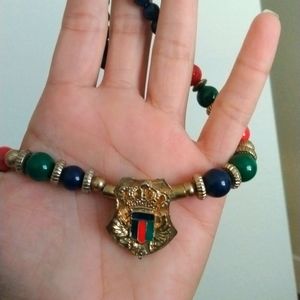 Navy, red and green beaded necklace with gold toned pendant